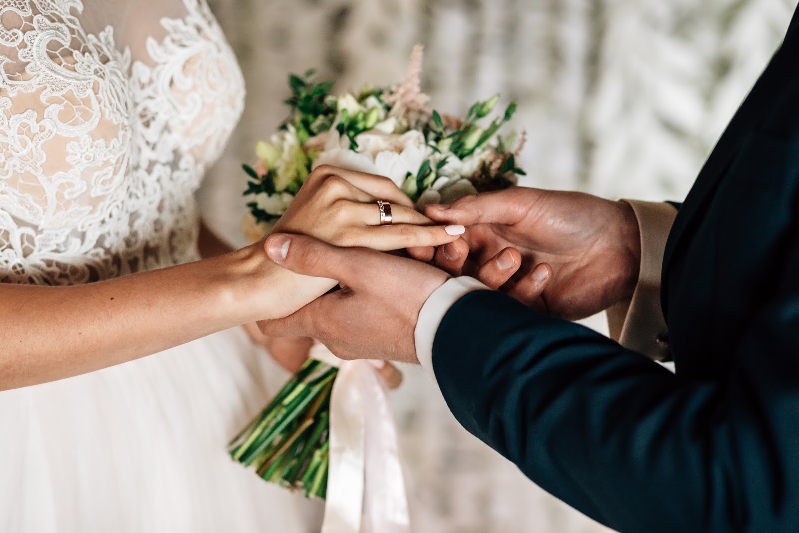 Ring exchange wording: A groom puts a ring on a bride's finger