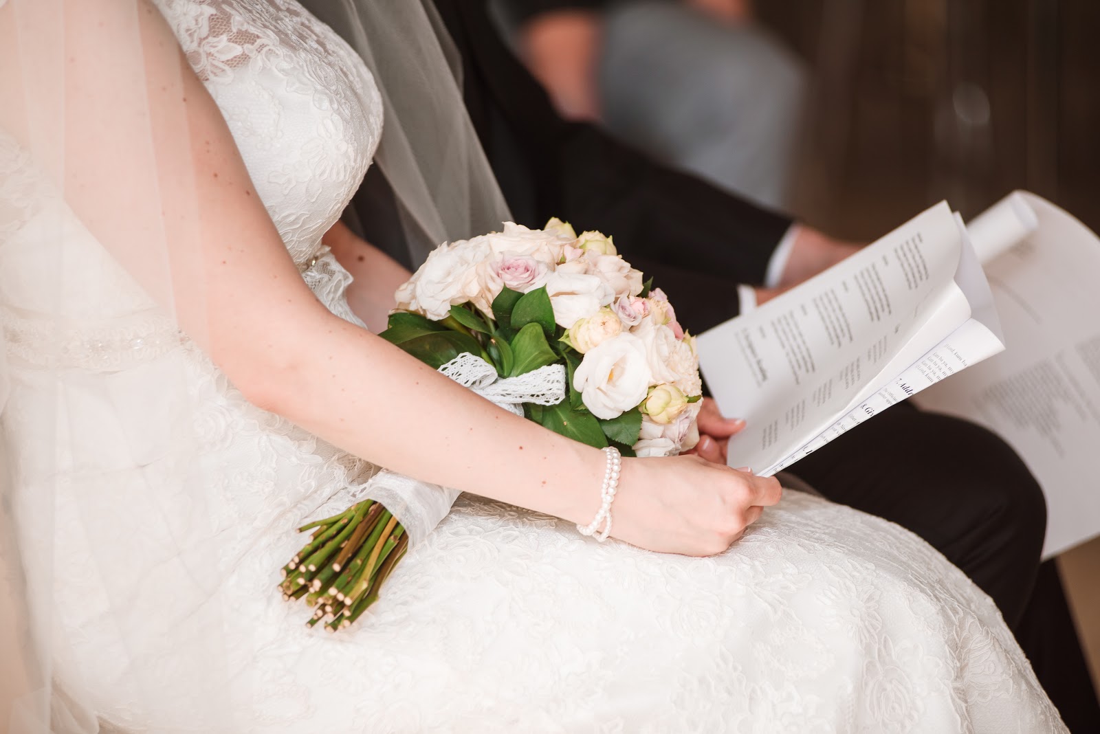 Wedding program wording: A bride and groom hold their programs