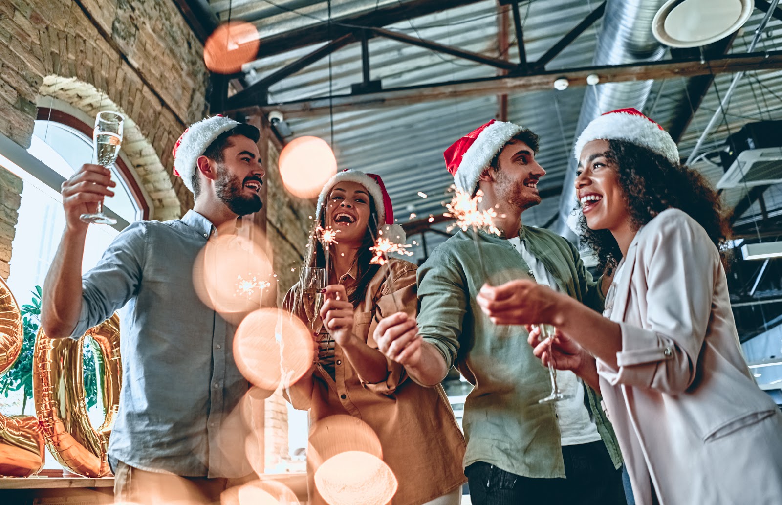Christmas party ideas: Guests hold sparklers and champagne flutes at a holiday celebration