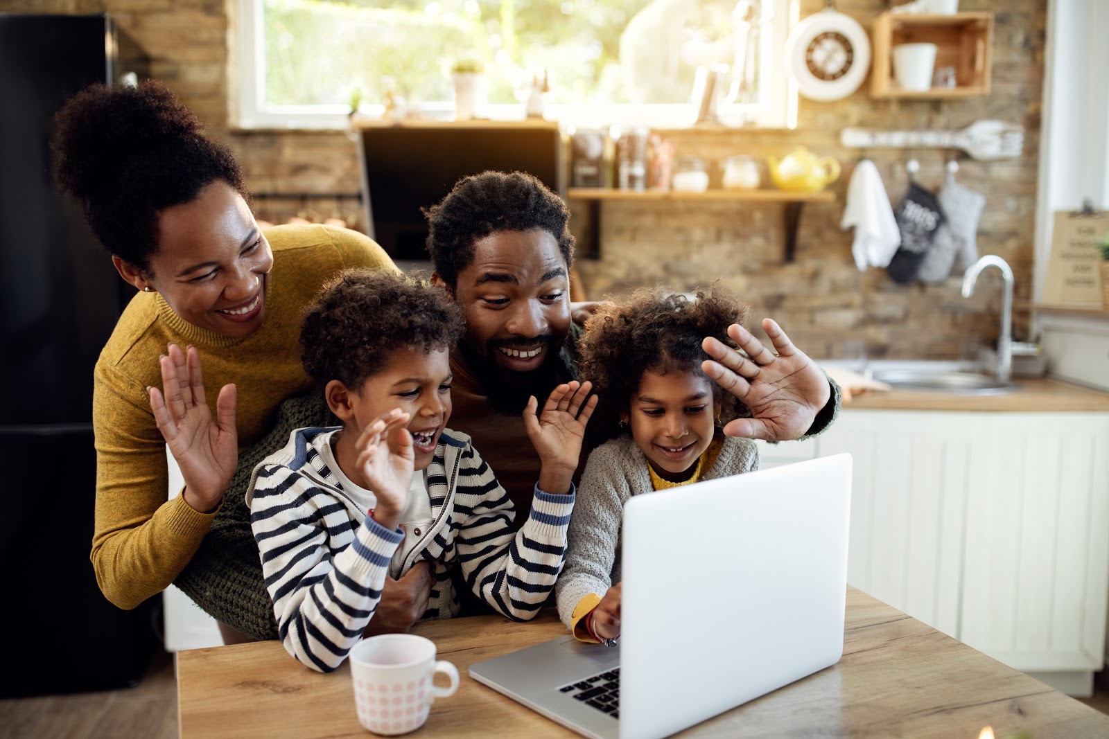 Virtual family games: Happy family and waving during a video call