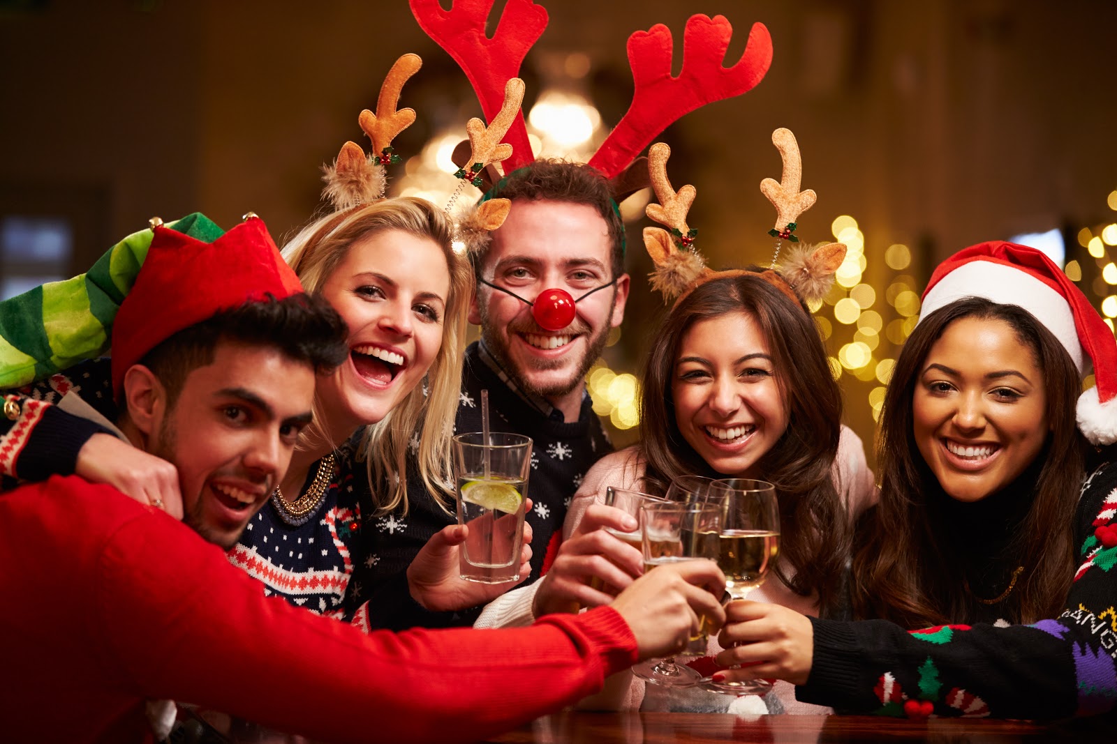 Christmas party ideas: A group wears reindeer antlers and holds up their glasses