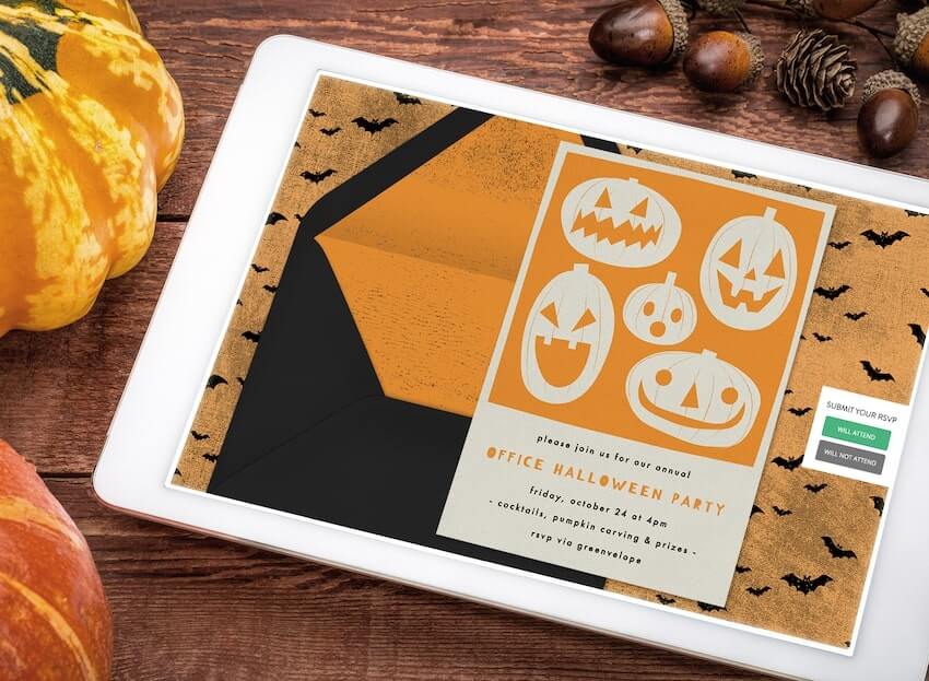 Halloween themes for work: Halloween invitation on a tablet screen beside mini pumpkins and acorns