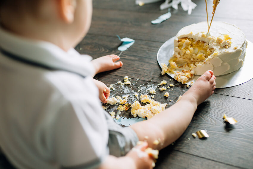 Wild one birthday theme: baby playing with his cake