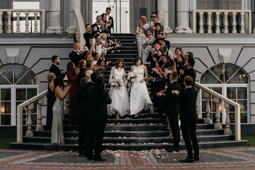 Black tie optional wedding: bride and bride walking down the staircase
