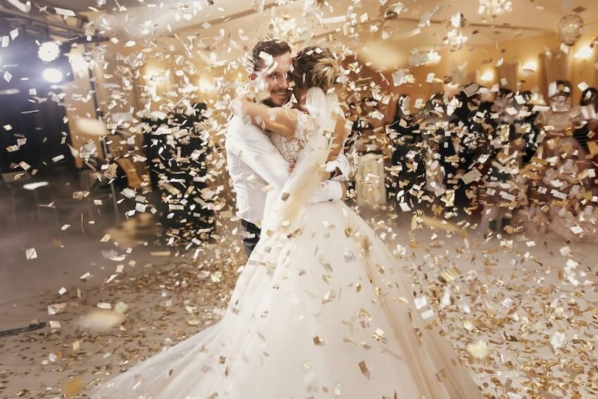 Wedding reception ideas: bride and groom dancing while confetti rains down around them