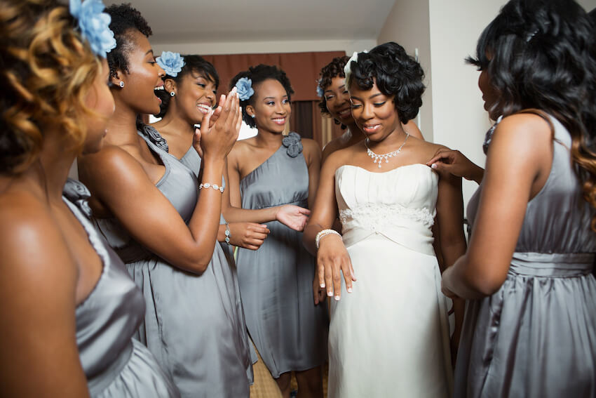 Bridesmaids helping a bride to get ready