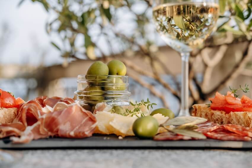Italian themed party: charcuterie board and a glass of wine on a table