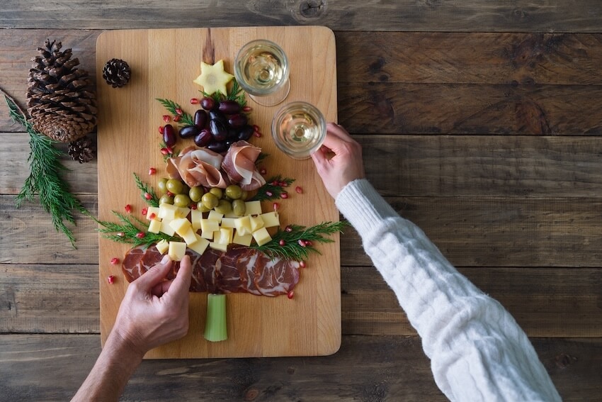 People getting food from a charcuterie board