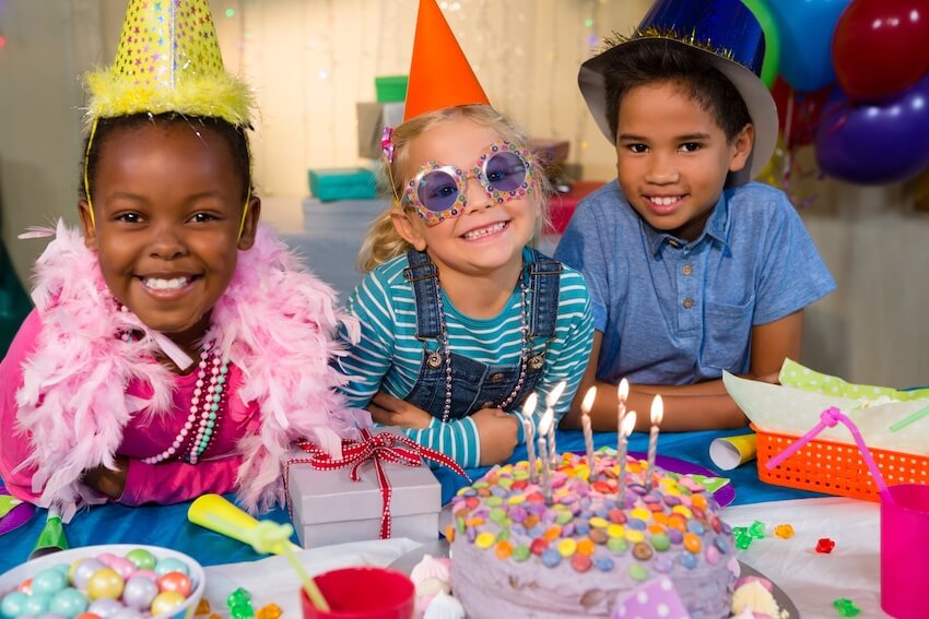 Wild one birthday theme: children wearing party hats and smiling at the camera