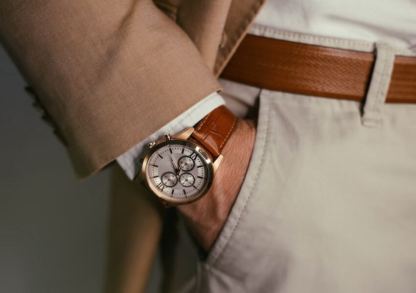 Closeup of a person’s hand in his pocket, wearing a watch