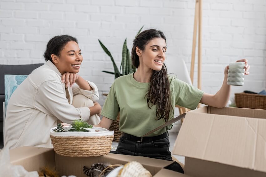 Housewarming gift ideas: couple happily unpacking boxes