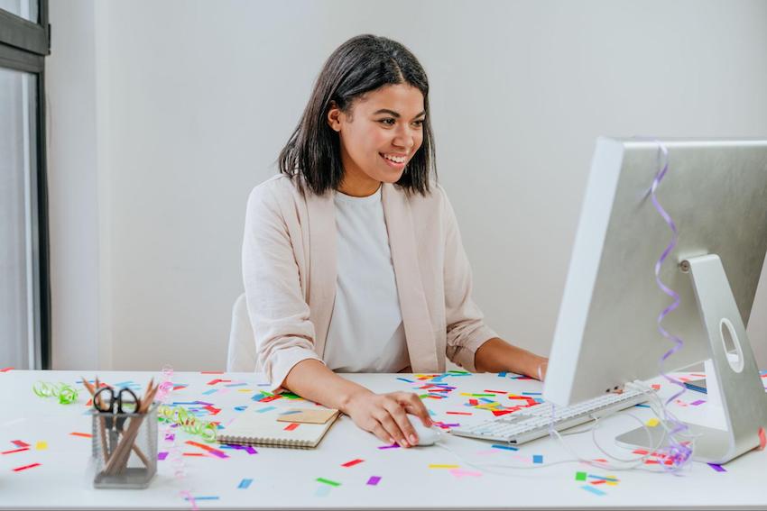 Party invitation maker: entrepreneur happily using a computer