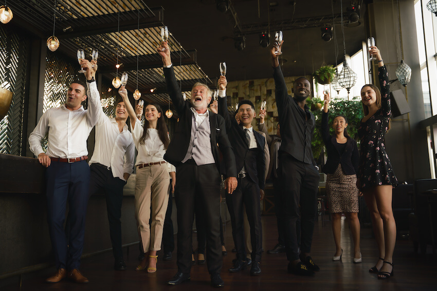 Retirement invitation wording: entrepreneurs celebrating and raising their glasses