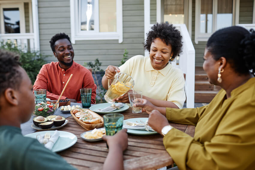 Summer BBQ: family happily eating outside
