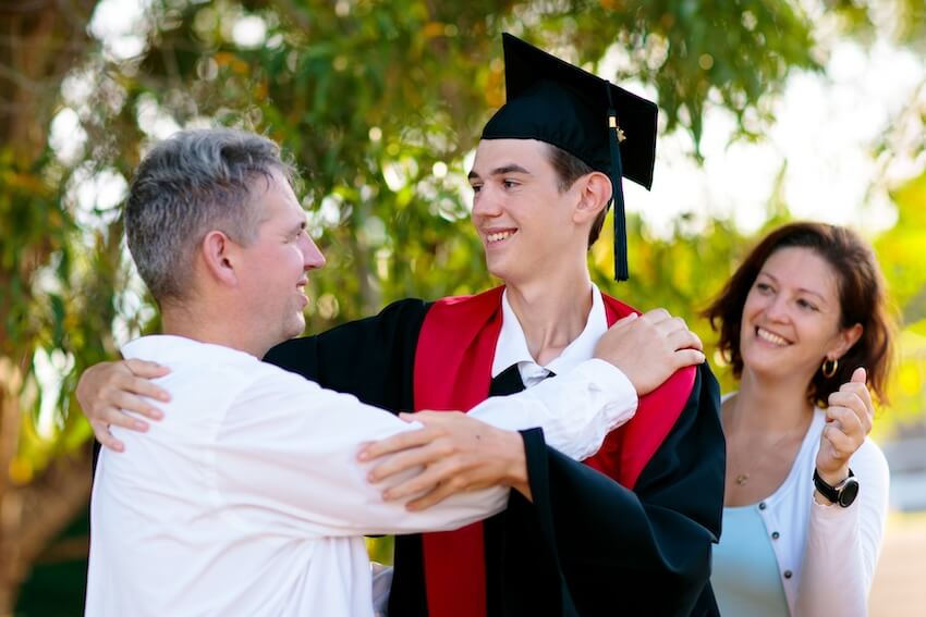 High school graduation wishes: father hugging his graduating son