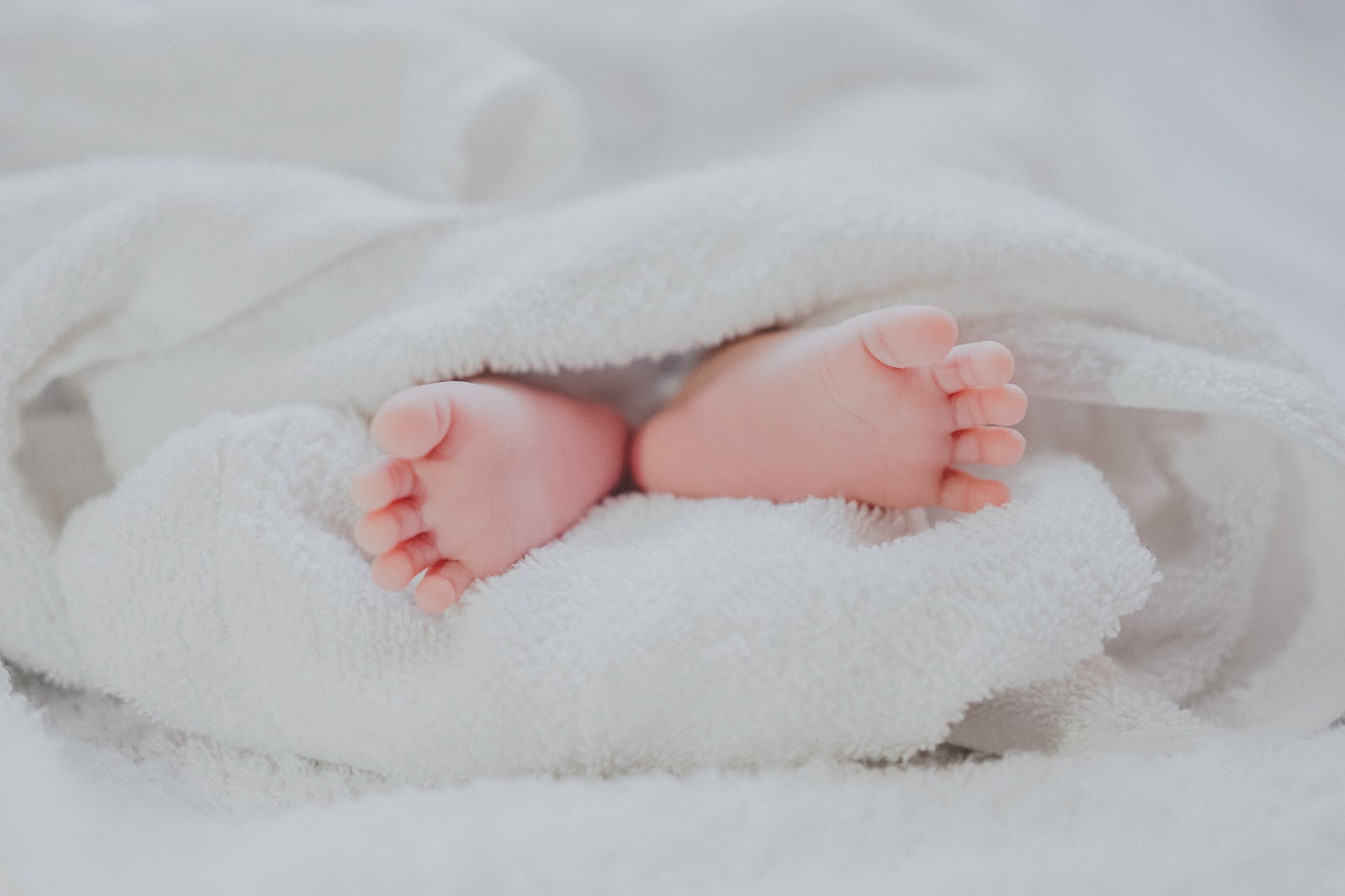 Baby feet coming out of a white blanket