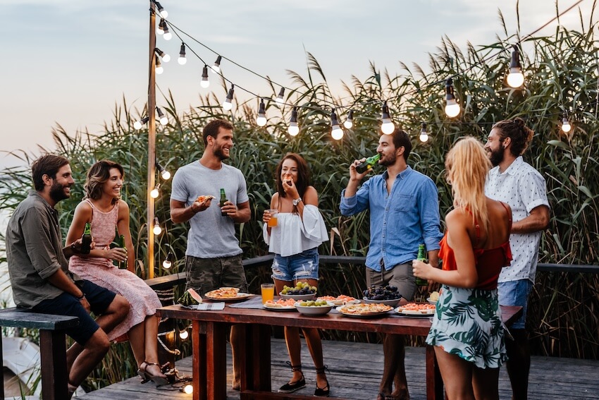 Summer theme party ideas for adults: friends drinking and eating outdoors