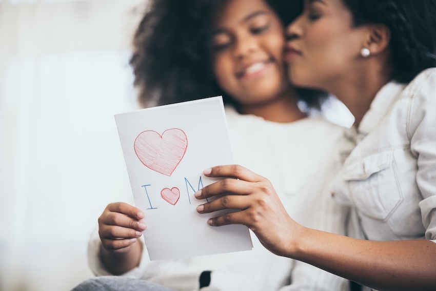 Girl giving a love card to her mom