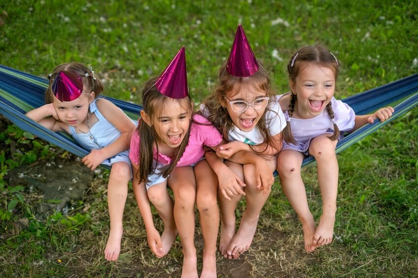 One happy camper birthday: girls sitting on a hammock