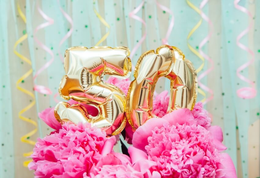 Turning 50 quotes: golden number 50 balloons on pink flowers