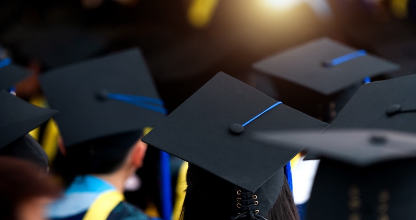 High school graduation wishes: back view of graduates wearing their graduation caps