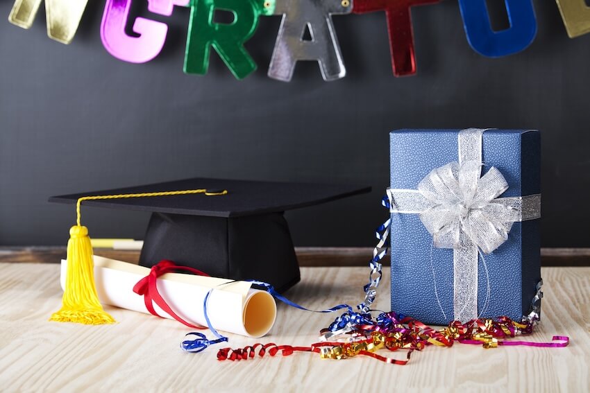 Graduation money gift ideas: graduation cap, diploma, and a gift