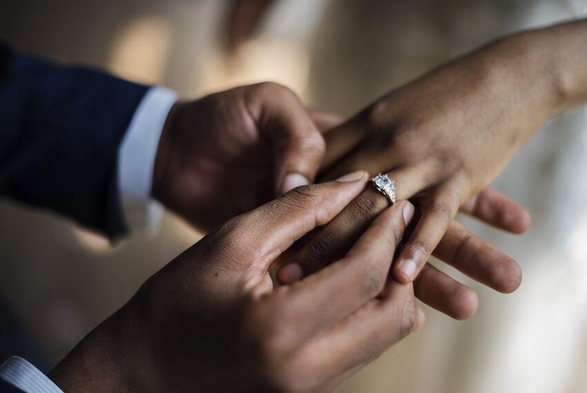 Groom placing a ring on the bride's finger