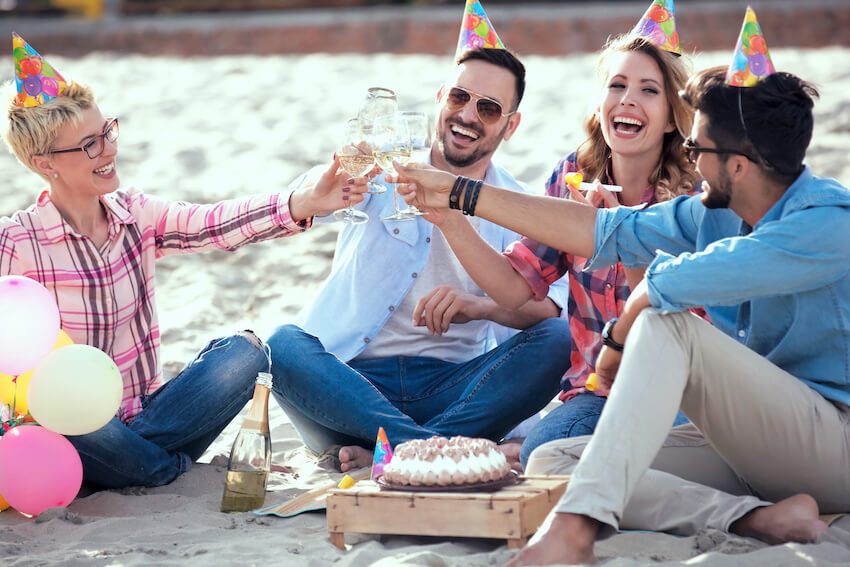 Beach birthday party: group of friends having a toast at a beach