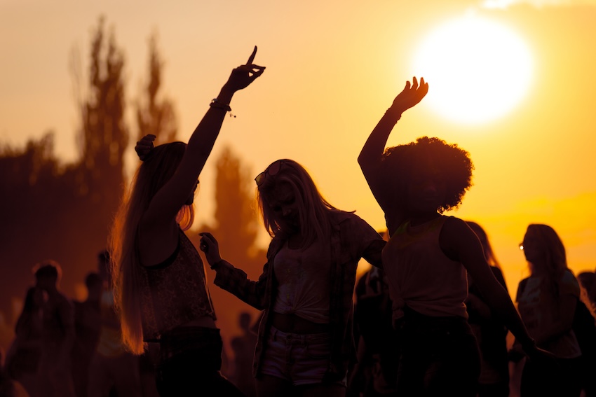 Group of people dancing at sunset