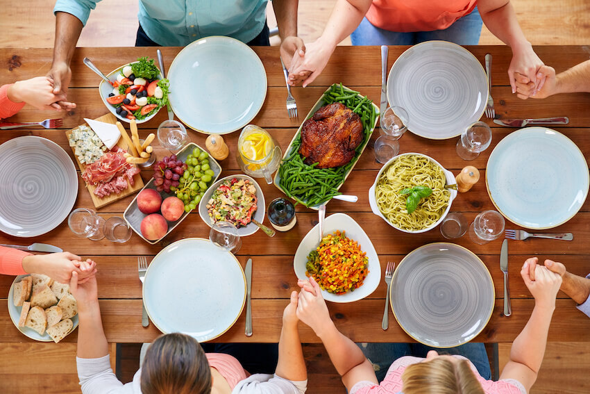 Top view of a group of people praying before a meal