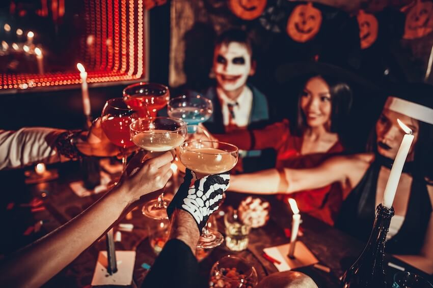 Murder mystery party ideas: group of people wearing costumes clinking their glasses