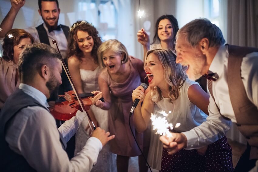 Questions to ask wedding venue: guests dancing and singing at a wedding reception