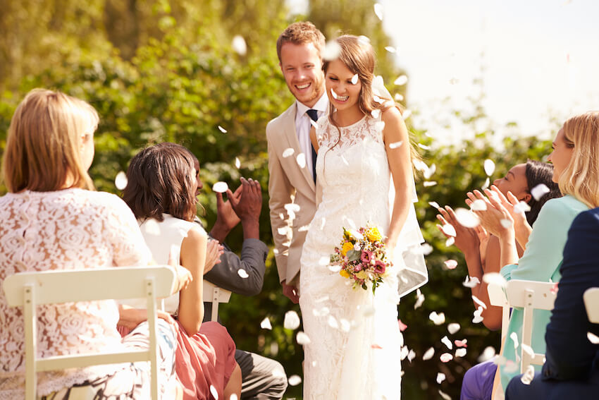 Guests throwing confetti to the bride and groom
