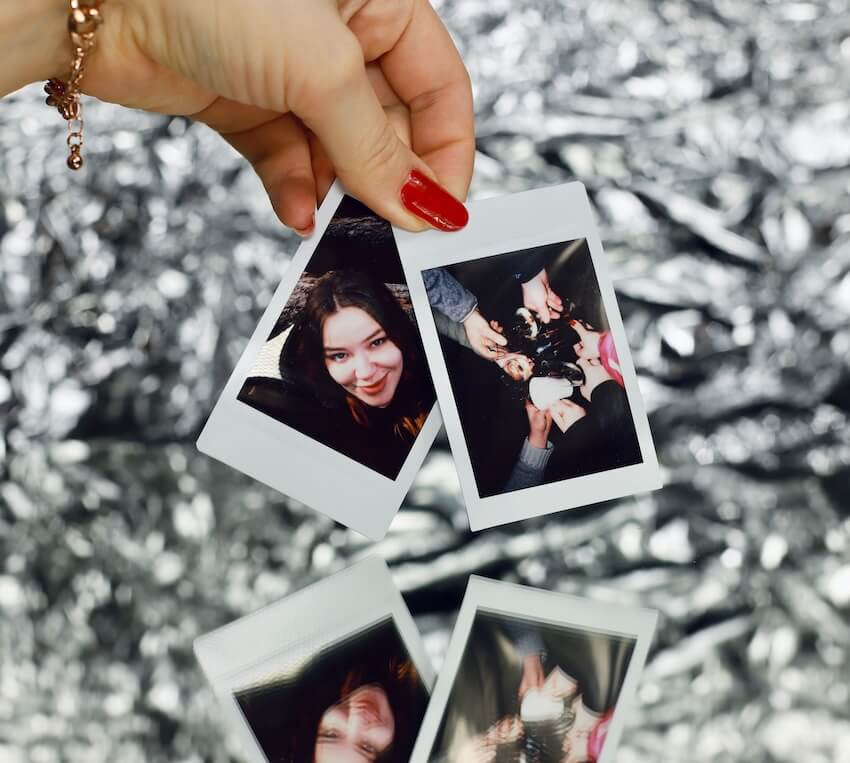 Close up of a hand holding two instant photos