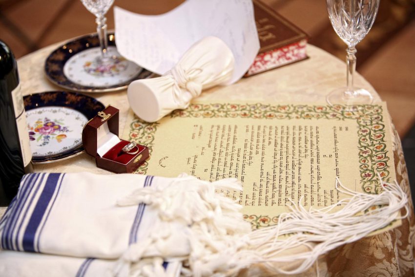 Jewish wedding invitation wording: letter and a ring on a table