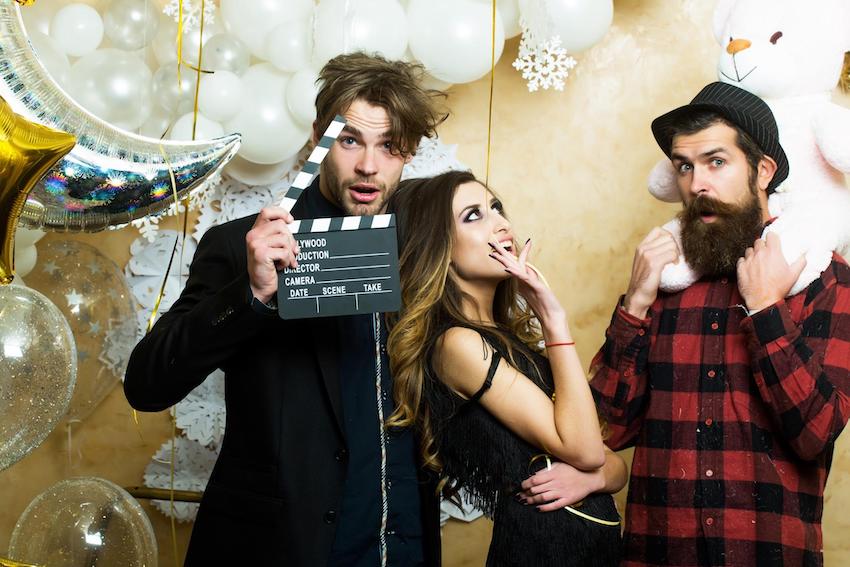 Hollywood theme party: 3 people posing with balloons, teddy bear and clapper