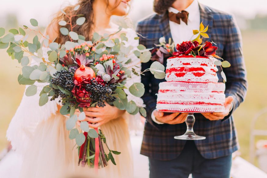 wedding on a budget: Groom holding the wedding cake and bride holding her bouquet