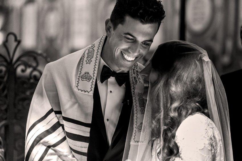 Jewish wedding invitation wording: Jewish bride and groom smiling