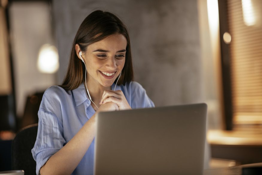 Woman smiling at her laptop screen