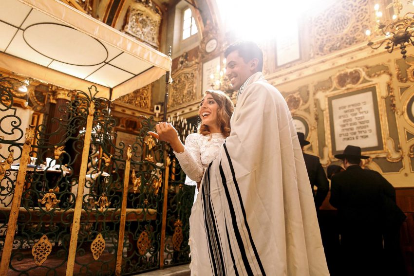 Jewish bride and groom smiling while dancing