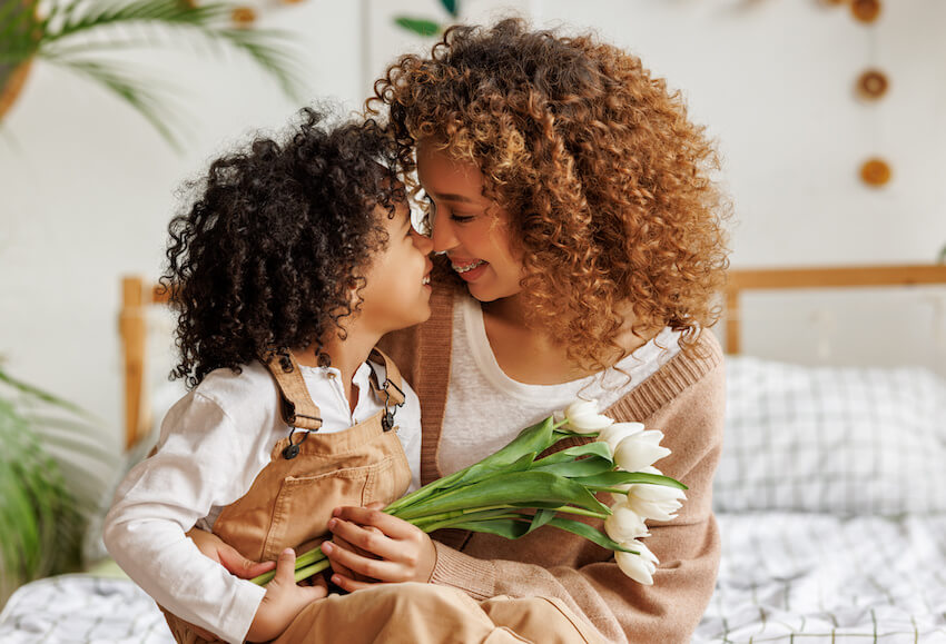 Happy Mothers Day wishes for all moms: kid giving her mother a bouquet of flowers