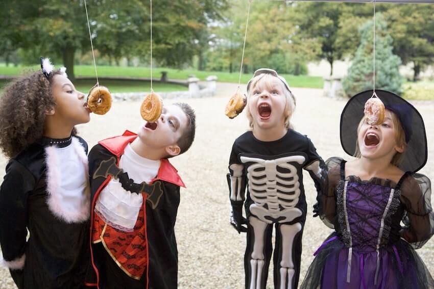 Halloween party ideas: kids eating donuts hanging from a string