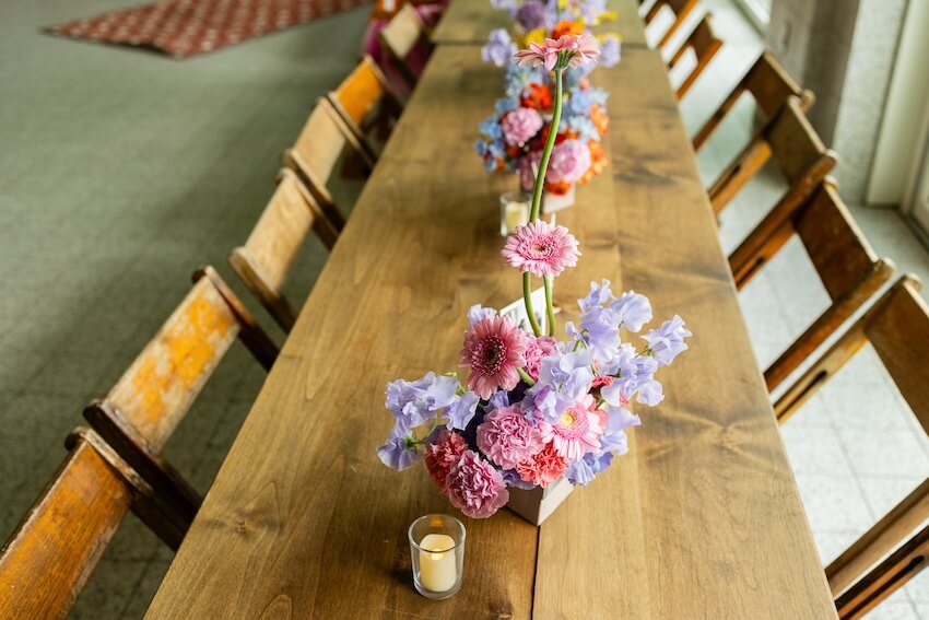 Summer bridal shower themes: long wooden table with candles and flowers