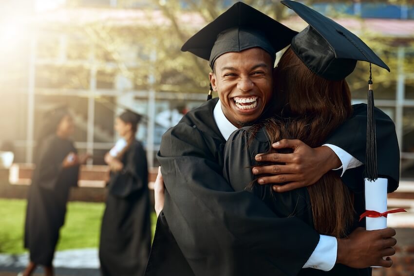 Graduation gifts for him: man happily hugging a woman on their graduation day