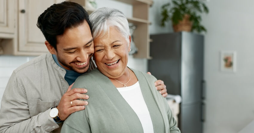 Man hugging his mother from behind