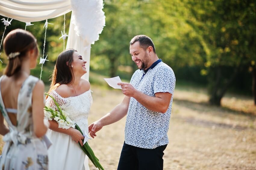 Man reading his wedding vow to his girlfriend