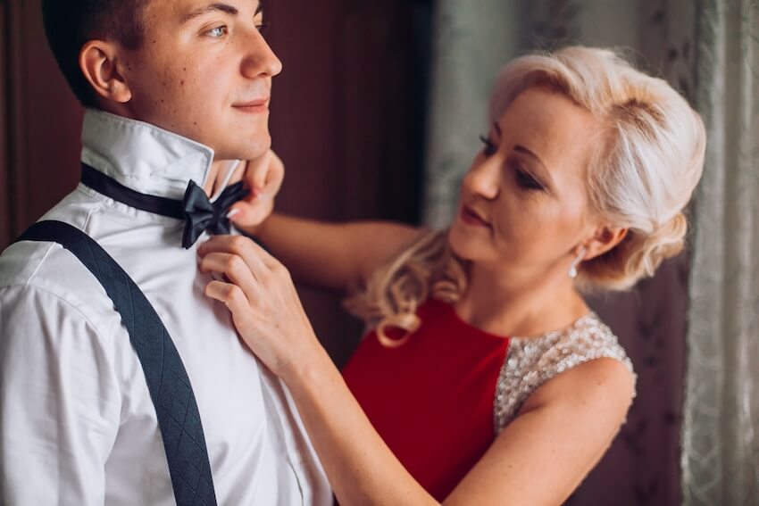 Mother son wedding songs: mother of the groom adjusting his bow tie