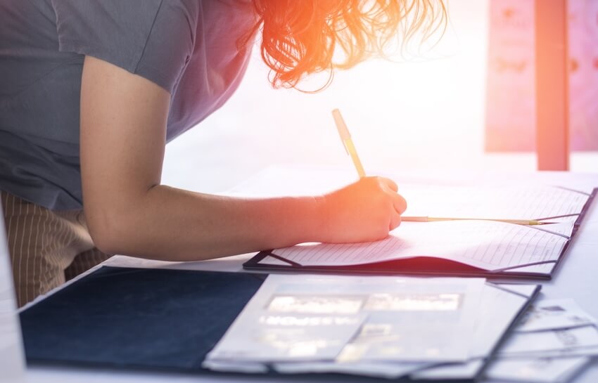 PTA meeting: mother writing on an attendance sheet