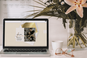 digital invitation on laptop computer sitting on a stylish desk with flowers
