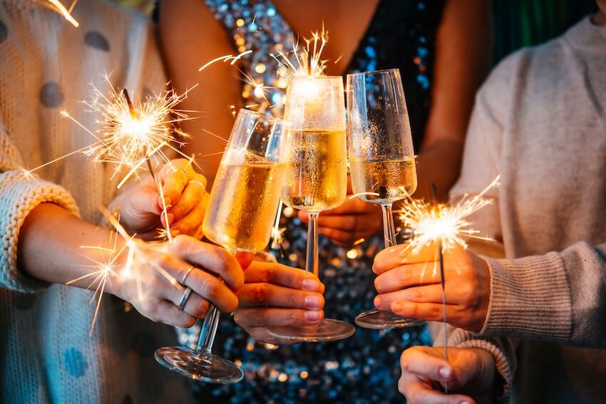 New years invitations: people having a toast while holding some sparklers
